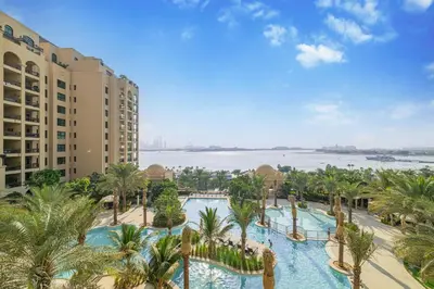 an aerial view of a resort with a pool and palm trees at Daniels 2BR at Fairmont South The Palm Jumeirah in Dubai