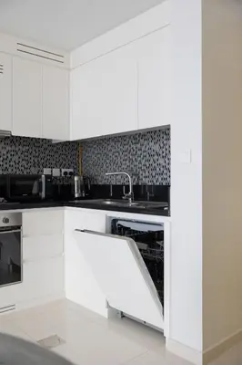 a kitchen with white cabinets and a sink at Cozy 2BR in Business Bay, Aykon Tower in Dubai