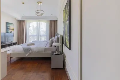 a white bedroom with a bed and a window at Spacious New 2 BDR, Pool and Beach Access in Dubai