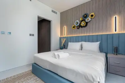 a bedroom with a large bed with a blue wall at Luxury apartment in Dubai center, District One in Dubai