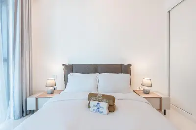 a bedroom with a white bed with two lamps at Stunning Beachfront Home with Panoramic Sea Views in Dubai