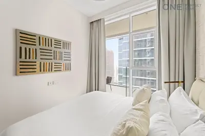 a bedroom with a white bed and a large window at Stylish 2BR in Business Bay canal View Pool & Gym in Dubai