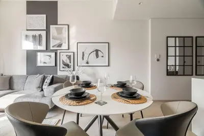 a living room with a white table and chairs at GuestReady - Burj Khalifa View l Infinity Pool in Dubai