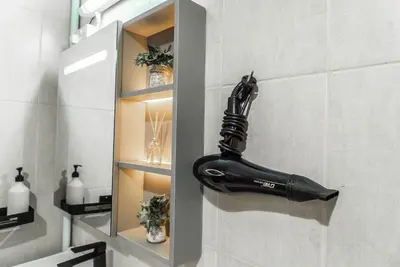 a bathroom with a blow dryer hanging on the wall at Studio in Dubai Pool, Gym & Stunning Views in Dubai