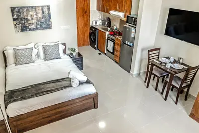 a bedroom with a large bed and a kitchen at Studio in Dubai Pool, Gym & Stunning Views in Dubai