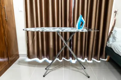 a table with a laptop on it in front of a curtain at Studio in Dubai Pool, Gym & Stunning Views in Dubai