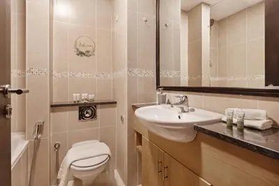 a bathroom with a sink and a toilet and a mirror at Luxury JLT Studio Lake View Metro & Marina in Dubai