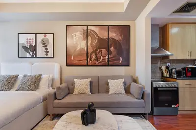 a living room with a couch and a horse painting on the wall at Luxury JLT Studio Lake View Metro & Marina in Dubai