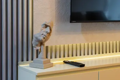 a statue of a head sitting on a table next to a tv at Luxury JLT Studio Lake View Metro & Marina in Dubai