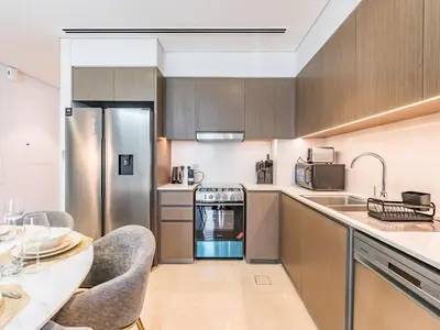 a kitchen with stainless steel appliances and a table at 2 BR - Grande Signature - Burj Khalifa View in Dubai