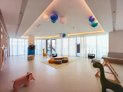 a large living room with balloons and dinosaurs on the floor at 2 BR - Grande Signature - Burj Khalifa View in Dubai