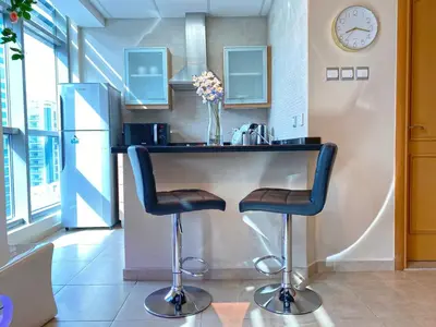 a kitchen with a counter with two bar stools at Elegant Studio in Marina near Beach and Metro Z1113 in Dubai
