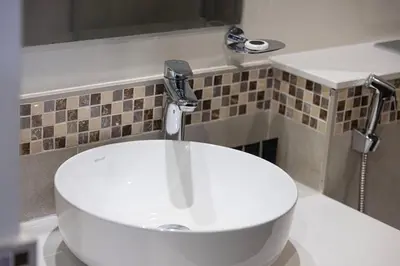 a white sink in a bathroom with a faucet at Exclusive 1-Bedroom Apartment with Breathtaking Burj Khalifa Views in the Heart of Dubai in Dubai