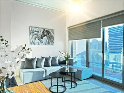 a living room with a couch and a table at Cozy 1 Bedroom Apartment with Marina and Sea View Z1306 in Dubai