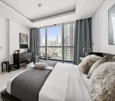 a bedroom with a large bed with a large window at Luxury Living in Sterling West in Dubai