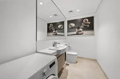 a white bathroom with a sink and a toilet at Luxury Living in Sterling West in Dubai