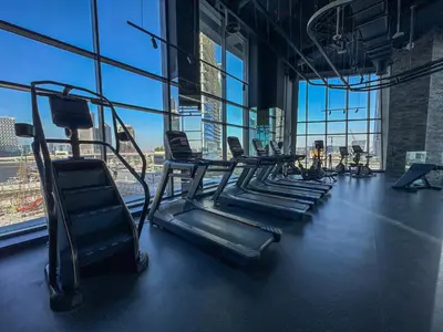 a gym with a row of treadmills and windows at Luxury 1BR in 15 Northside Tower with Canal View 4AB03 in Dubai