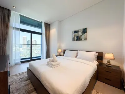 a bedroom with a large bed and a large window at Luxury 1BR in 15 Northside Tower with Canal View 4AB03 in Dubai