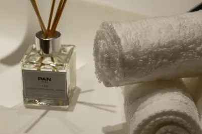 a bottle of plan perfume next to a roll of toilet paper at Burj & Beyond - Luxury Stay with Burj Khalifa View in Dubai