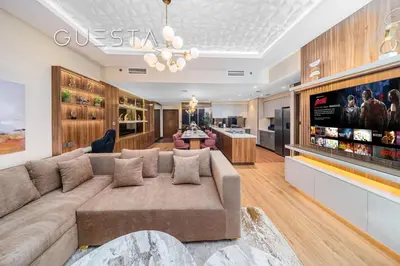 a living room with a large couch and a bar at Forte Tower 1 by Emaar - Dubai Fountain View, Downtown Dubai in Dubai