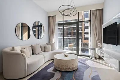 a living room with a white couch and a table at 1BR Azizi Riviera B7, Pool View in Dubai