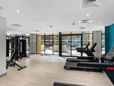 a gym with treadmills and cardio equipment in a building at 1BR Azizi Riviera B7, Pool View in Dubai