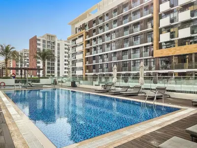 a large swimming pool in front of a building at 1BR Azizi Riviera B7, Pool View in Dubai