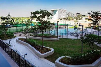 a park with a pool and a playground with trees at City Walk Green Planet View 1Br in Dubai