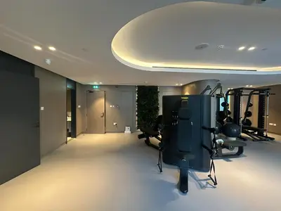 a room with a gym with exercise equipment in it at Bespoke Holiday Homes - Stylish 1-BR Apartment in Oxford Terraces, JVC in Dubai