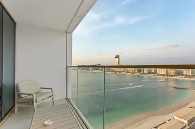 a chair on a balcony with a view of the ocean at Seaview Living 2 Bedroom - Grand Bleu by Elie Saab in Dubai