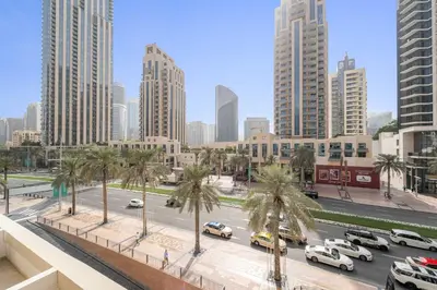 a city with cars parked on a street with palm trees at Silkhaus Modern Studio with Burj Khalifa View in Dubai