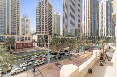a city with cars parked in a parking lot with tall buildings at Silkhaus Modern Studio with Burj Khalifa View in Dubai