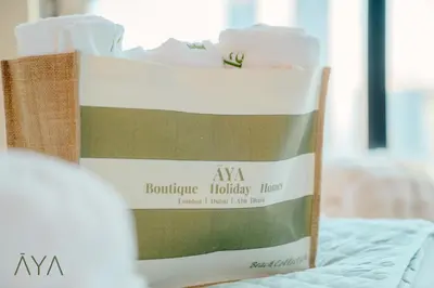 a bag of towels sitting on top of a bed at Luxury Beachfront 1BR Jumeirah Gate Tower 1 By ĀYA Boutique in Dubai