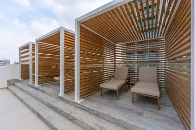 a patio with two chairs and a wooden wall at Smart living I High speed wi-fi I City view in Dubai