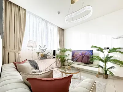 a living room with a couch and a table at Trophy - Elegant Cozy 1Bdr in Sobha Hartland in Dubai