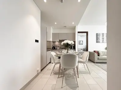 a kitchen and dining room with a table and chairs at Trophy - Elegant Cozy 1Bdr in Sobha Hartland in Dubai