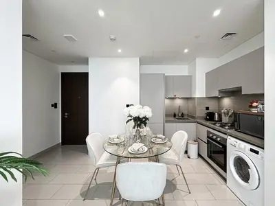 a kitchen with a table and chairs in a kitchen at Trophy - Elegant Cozy 1Bdr in Sobha Hartland in Dubai