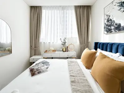 a bedroom with a bed and a blue couch at Trophy - Elegant Cozy 1Bdr in Sobha Hartland in Dubai
