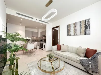 a living room with a couch and a table at Trophy - Elegant Cozy 1Bdr in Sobha Hartland in Dubai