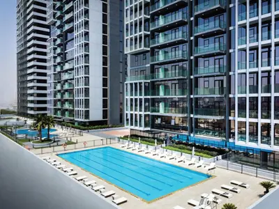 an overhead view of a swimming pool in front of tall buildings at Stylish Studio Living in the Heart of JVC in Dubai