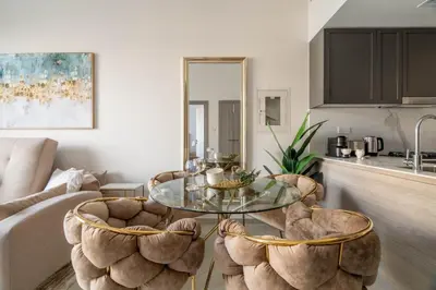 a living room with a glass table and two chairs at GuestReady - Glamorous retreat in JVC in Dubai