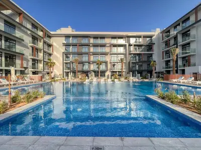 a large swimming pool in front of a building at GuestReady - Glamorous retreat in JVC in Dubai