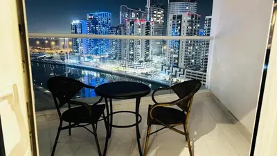 a table and chairs on a balcony with a view of the city at Luxurious studio in Damac maison prive by Phineek vacation home in Dubai
