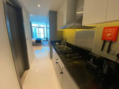 a kitchen with a stove and a counter top at Luxurious studio in Damac maison prive by Phineek vacation home in Dubai