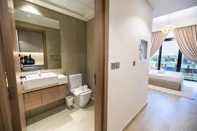 a bathroom with a toilet and a sink and a mirror at Elite LUX Holiday Homes - Upscale Studio in Azizi Riviera Prime Location Dubai in Dubai
