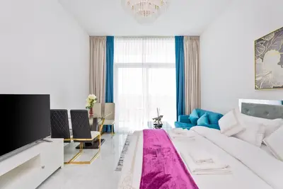 a bedroom with a large bed with a pink blanket at Vacay Lettings - Pearlz By Danube -Studio-Al Furjan-Near Metro in Dubai