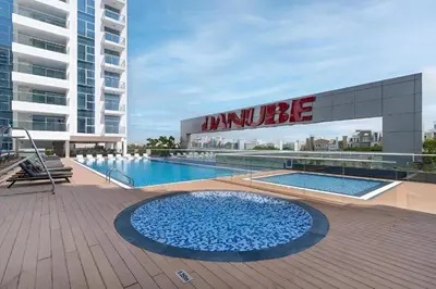 a large swimming pool in front of a building at Vacay Lettings - Pearlz By Danube -Studio-Al Furjan-Near Metro in Dubai