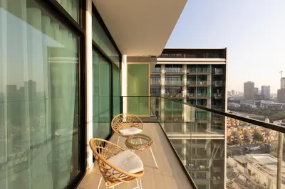 a balcony with two chairs and a view of a city at Cozy 1BR with balcony in Binghatti Emerald in Dubai