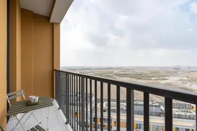 a balcony with a bench and a view of a city at Vacay Lettings - Spacious Studio Apartment - Production City in Dubai