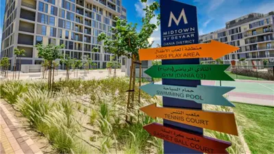 a directional sign in front of a building at Vacay Lettings - Spacious Studio Apartment - Production City in Dubai